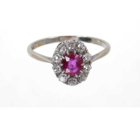 Antique ruby and diamond cluster ring with an oval mixed cut ruby measuring approximately 5.9mm x 5.1mm surrounded by ten old
