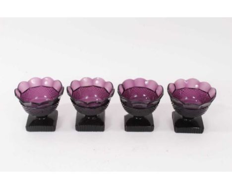 A set of four 19th century amethyst tinted glass salts, the bodies with diamond-cut decoration, over square cut bases, 7.25cm