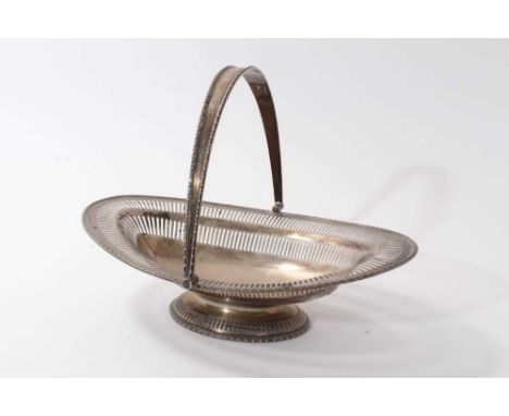 George V silver swing handled cake basket, with pierced decoration and bead border, on a pierced oval base (Sheffield 1917) H