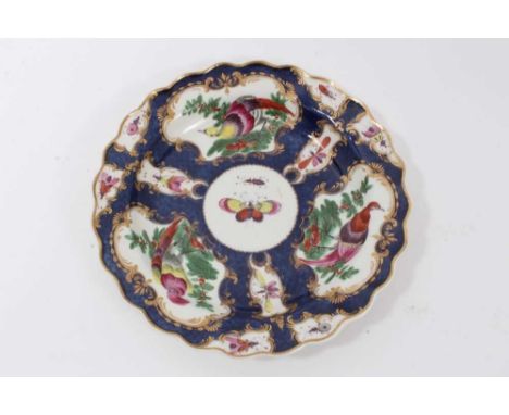 A Worcester plate, circa 1770, with wavy rim, polychrome decorated with panels of birds and insects on a blue scale ground, w