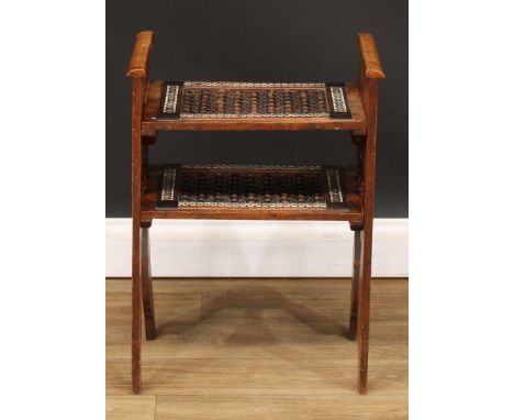 A North-African two-tier table, probably Moorish, shaped and pierced end supports carved in the Islamic taste and inlaid with