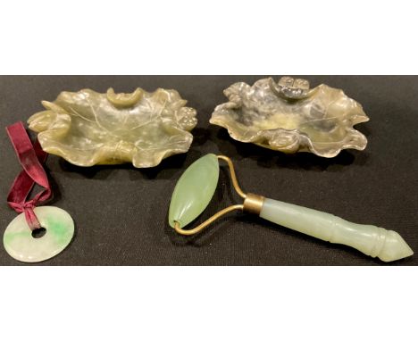 A Chinese jade roundel; a roller; a pair of carved soapstone brush washers, as lotus leaves (4) 