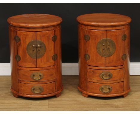 A pair of Chinese design cylindrical lamp or bedroom cabinets, each with a pair of doors above two drawers, 62cm high, 44cm d