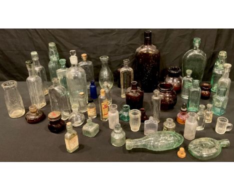 A collection of glass advertising bottles including Midland Hotel, Derby pumpkin whisky flask; Dawber, Lincoln coffin flask; 