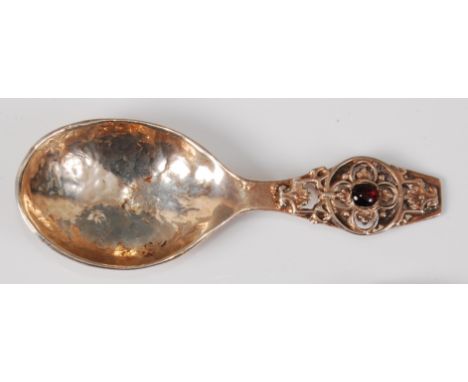 *A late Arts & Crafts silver caddy spoon, the hammered bowl terminating with applied floral strapwork and pierced decoration,