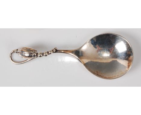 Georg Jensen (1866-1935) - a 1920s/30s sterling silver caddy spoon, having a plain shallow bowl with floral stylised terminal