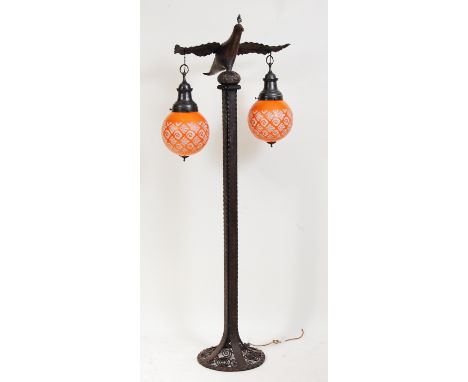 A French Art Deco wrought iron floor lamp, modelled as a bird perched on a column upon spiral work circular base, with twin h