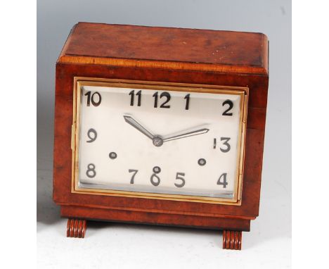 An Art Deco figured walnut cased mantel clock, having a silvered square dial with striking and chiming eight day quarter repe