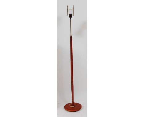 A 1960s Danish teak standard lamp, having gilt brass upper rod to turned column and circular integral base, h.141cm