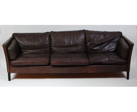 A 1970s Danish chocolate brown leather three-seater sofa by Thams, raised on ebonised square supports with label beneath cush