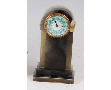 A 1930s verde antico marble bedside alarm clock, the case of arched and stepped form, the circular dial guilloche enamel deco