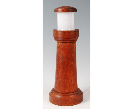 An Art Deco turned oak lighthouse table lamp, having milk glass cylindrical inset shade, on integral turned pedestal base, h.
