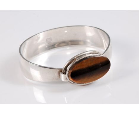 A Danish silver and tigers eye bangle by Niels Erik From, the oval tigers eye disc, approx. 25mm long, in collet mount, with 