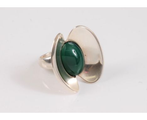 *A silver and prasiolite ring by Astrid Fog (1911-93) for Georg Jensen, the oval chrysoprase cabochon set to either side by a