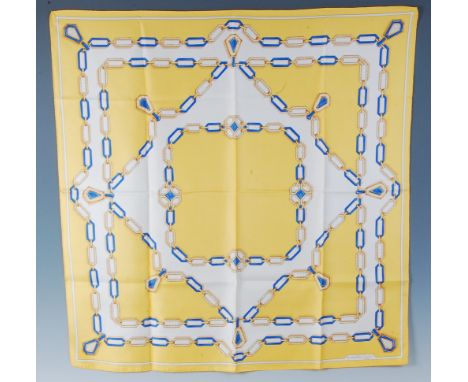 A Must de Cartier of Paris silk scarf, having a yellow ground with trailing chain-link and pendant decoration, marked Le Must