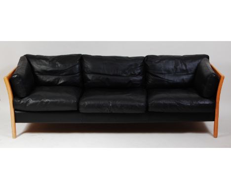 A 1980s Danish black leather three-seater sofa by Friis, having a beech frame on slightly curved end supports, w.210cm