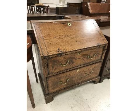 An 18th Century elm bureau the sloping fall enclosing a basic fitted interior over two drawers with brass swan neck handles r
