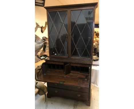 A 19th century mahogany secretaire bookcase, the upper section with 2 glazed doors enclosing adjustable shelving over a fitte