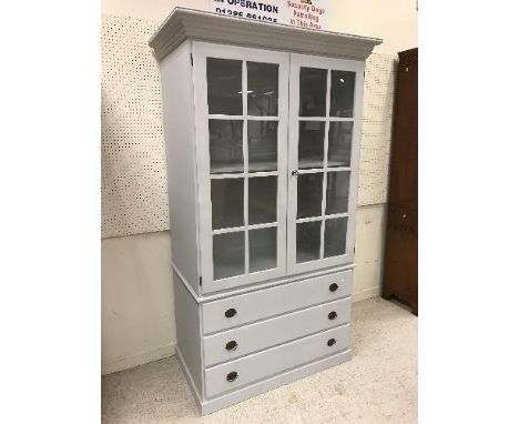 A modern painted cabinet on chest, the glazed top, the two glazed doors opening to reveal a shelf above three long drawers on