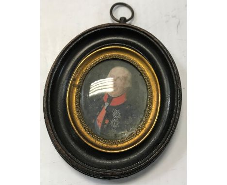 A 19th Century miniature of a decorated gentleman with red collar, sash and medals, housed in an oval frame, indistinct inscr