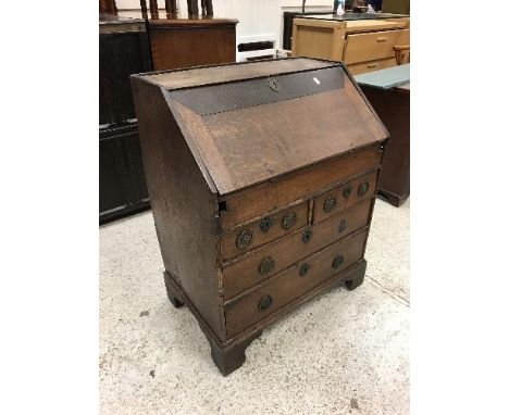 An oak bureau in the 18th Century manner, the sloping fall enclosing a basic fitted interior with well over two short and two