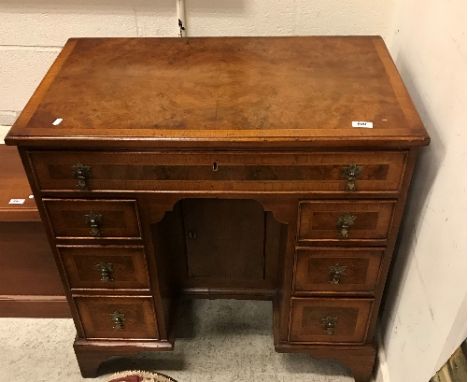 A burr walnut kneehole desk in the early 18th Century manner, the top feathered and crossbanded within a moulded edge over a 