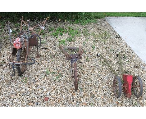 A collection of vintage tools comprising a crop sprayer, a Russell seed sower and a hand tiller