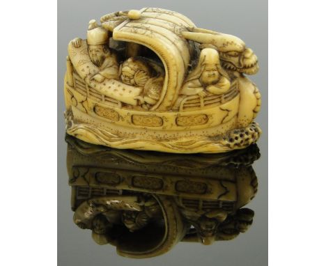 A 19th century Japanese ivory netsuke
depicting figures in a boat, 1.9", signed.