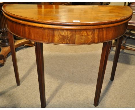 An Antique mahogany demi-lune foldover card table,
raised on square tapered legs, width 3'3", height 2'5.5".