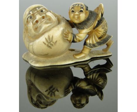 A 19th century Japanese ivory netsuke
depicting a figure rolling another, signed, length 1.75".