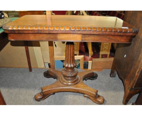 A 19th century rosewood foldover card table,
with carved edge raised on fluted centre column and platform base, width 3', hei