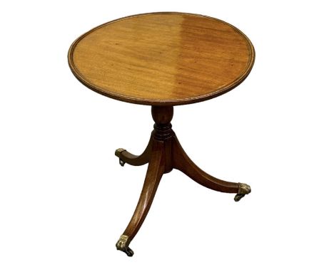 A mahogany tripod occasional table on brass claw feet, diameter of top 53cm.