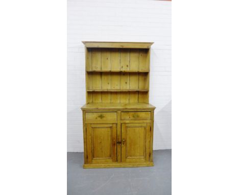 A Country pine kitchen dresser with a planked shelf plate back over a rectangular top with two short drawers and a pair of pa