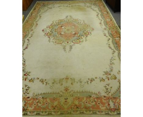 A large Indian carpet, the cream field with central floral medallion and spandrels within pale green and rose coloured floral