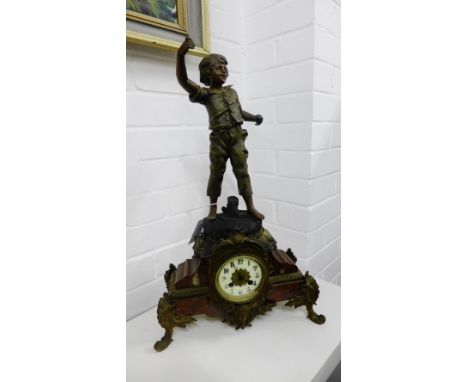 A French mantle clock, the enamel dial with Arabic numerals set to a red hardstone base with gilt metal mounts, surmounted by