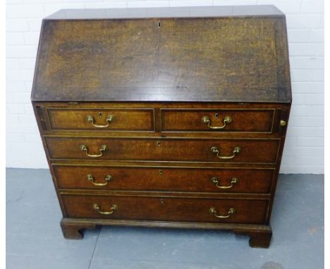 An oak bureau, the fall front opening to reveal a fitted interior over two short drawers and three graduated long drawers, on