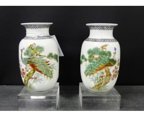 A pair of 20th century Chinese white glazed baluster vases painted with Peacocks, lingzhi tree and blossom below black ruyi b