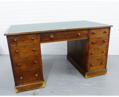 An oak partners desk, the rectangular top with an inset green leather skiver over one long drawer and four drawers to each pe