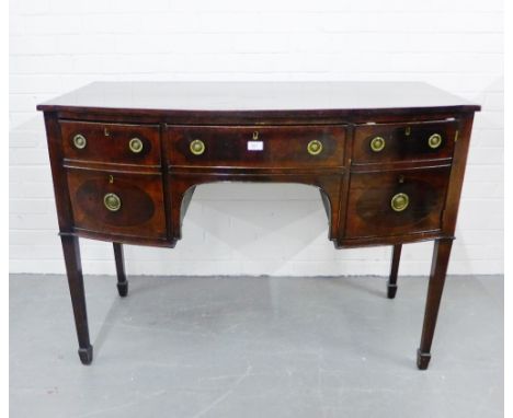 A mahogany sideboard, the bow fronted top over a central long drawer flanked by a cupboard door and one deep drawer on taperi