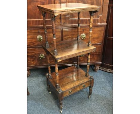 A Victorian rosewood three tier whatnot, with single shelf above drawer base, on turned supports and castors, 45.5cm