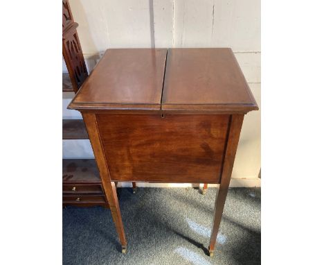 An early 20th century mahogany 'surprise' drinks table cabinet with rising top and shelf fitted with spaces for decanters, bo