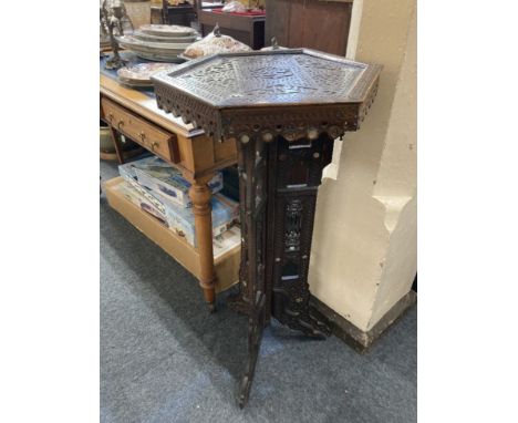 A late 19th century Spanish Moorish torchiere with hexagonal top, carved and fretted with mother of pearl inlay on folding tr