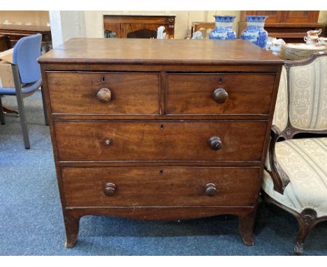 A George III mahogany flat front chest of two short over two long drawers, with turned knob handles, on splayed bracket feet,