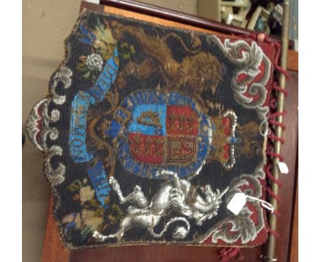 An Antique beadwork hanging with brass pole and Coat of Arms design.