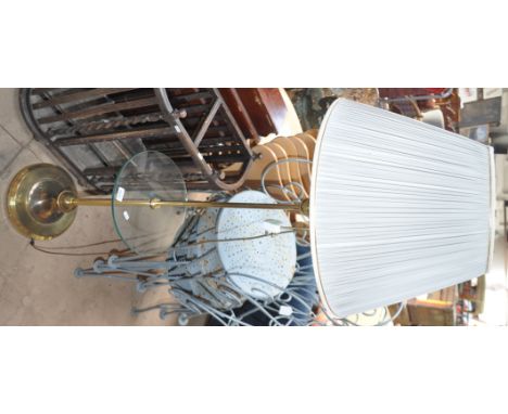 A brass and glass standard lamp with shade