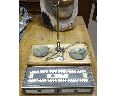 A scale on drawer fitted oak base with brass weights, and an Anglo-Indian inlaid cribbage board.