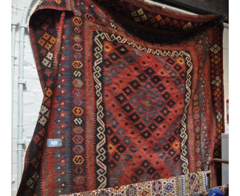 A large red ground Kilim carpet.