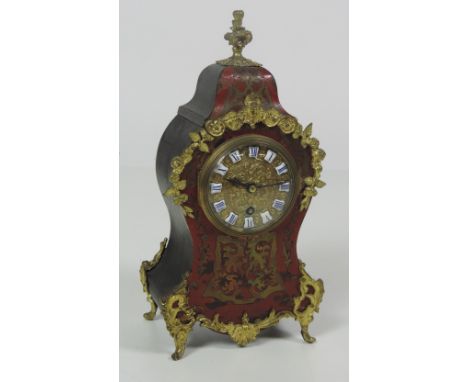 A small 19th Century red boulle and ormolu mounted Mantle Clock, in the French style, with ornate circular brass dial with en