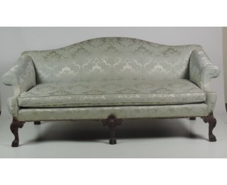 A large and elegant three seater hump back Settee, in the George II style, with five finely carved mahogany legs with mask de