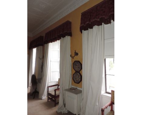 Three very heavy pairs of lined and inter-lined cream coloured linen Curtains, with crimson red pleated pelmets with large fr